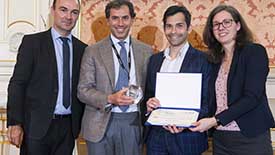 James Kwan holding award with three other people